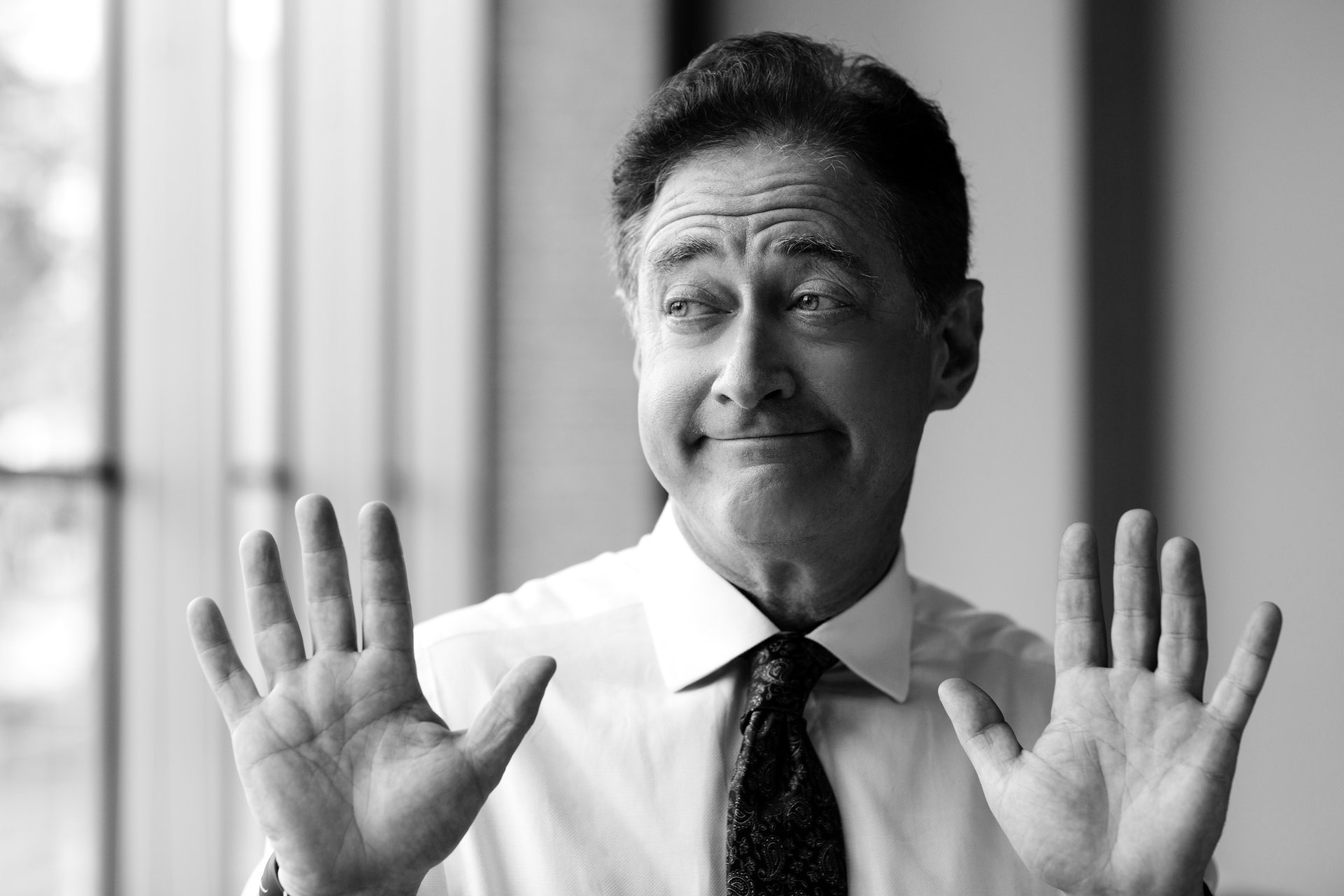 A business client raising both hands to turn down a sales presentation.